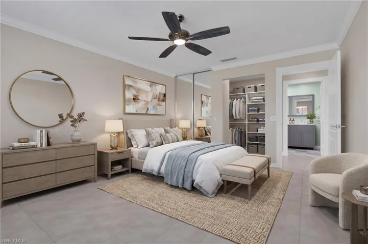Tile flooring, crown molding, ceiling fan, mirrored closet doors, and built-in closet organization