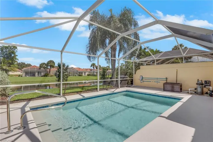 Screened outdoor pool with integrated steps, stainless steel handrail, and a surrounding patio