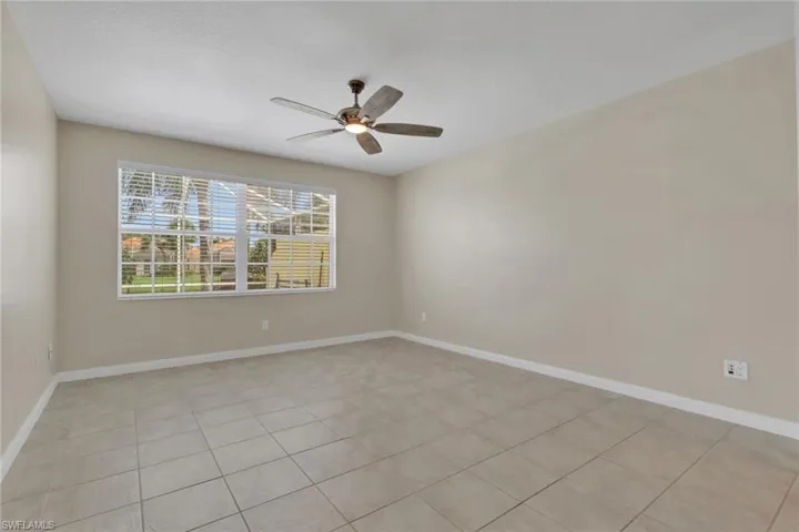 Neutral wall color, ceiling fan, large window with blinds, tile flooring, white trim