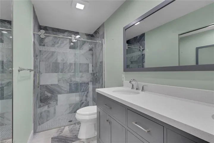 Walk-in shower with glass enclosure and decorative tile