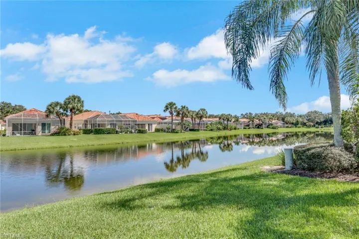 Lakeside properties featuring screened enclosures, tile roofs, and mature palm trees