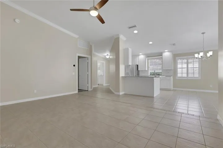Expansive tiled flooring throughout, complemented by a ceiling fan with integrated lighting