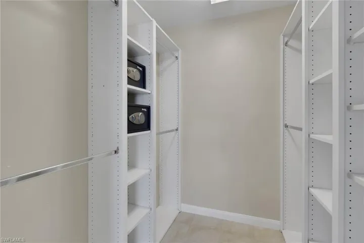 Custom closet system featuring multiple shelving units and chrome hanging rods