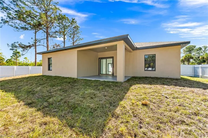 Rear view of property with a yard and a patio area