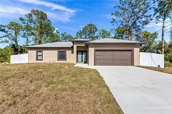View of front of property featuring french doors, a front yard, and a garage