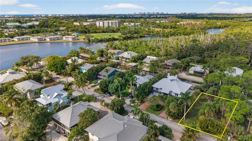Aerial view of residential area with a large body of water and property parcel outlined