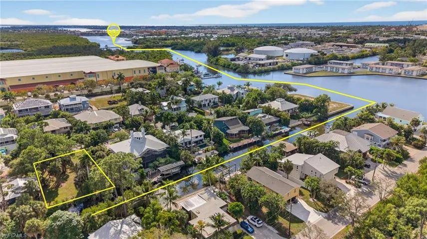 Aerial view of property and surrounding area with property boundaries highlighted and a large body of water
