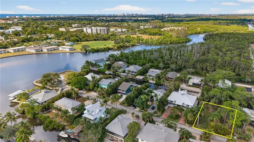 Aerial view of residential area with a large body of water and property parcel outlined