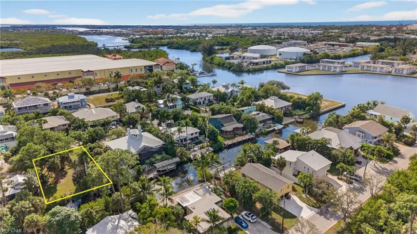 Aerial perspective of suburban area featuring property boundaries highlighted and a large body of water
