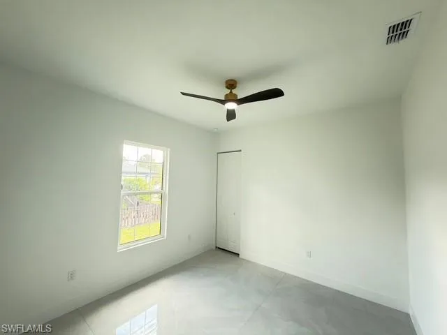 Empty room featuring baseboards and ceiling fan