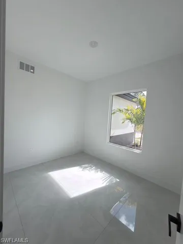 Empty room featuring a raised ceiling and ceiling fan