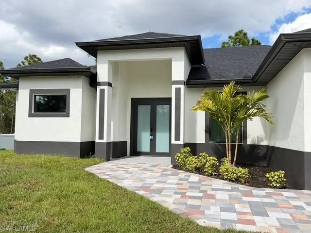 Prairie-style house with french doors, stucco siding, a garage, and decorative driveway