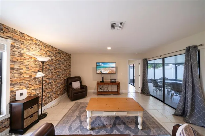 Living area featuring light tile patterned floors and recessed lighting