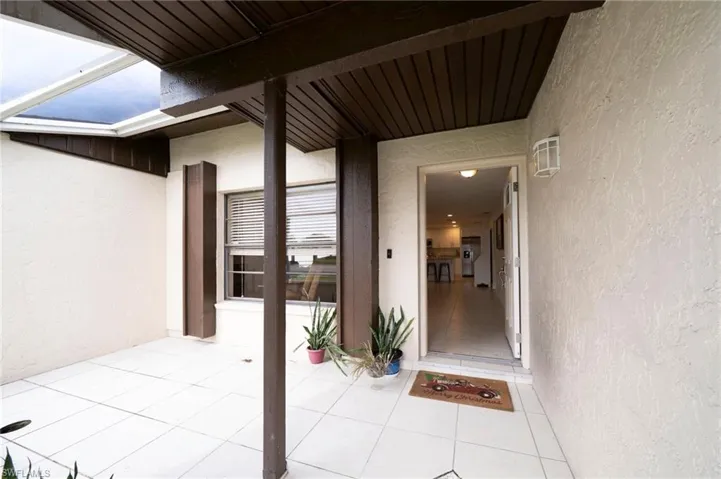 Property entrance featuring stucco siding and a patio area