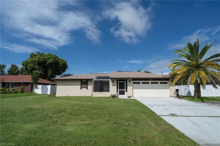 Ranch-style house with concrete driveway, stucco siding, a front lawn, and an attached garage