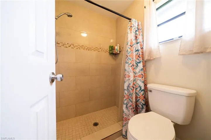 Full bathroom with a stall shower and toilet