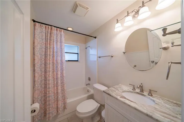 Full bath featuring shower / bath combination with curtain and vanity