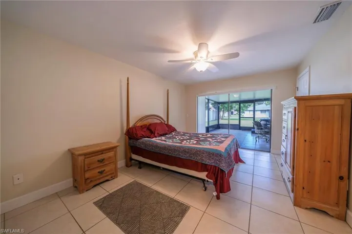 Bedroom featuring access to exterior, light tile patterned floors, and ceiling fan