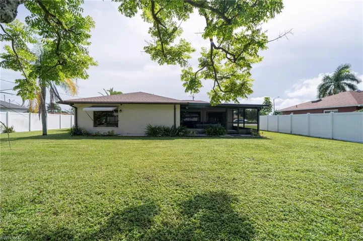 Rear view of property with a sunroom, a fenced backyard, and stucco siding
