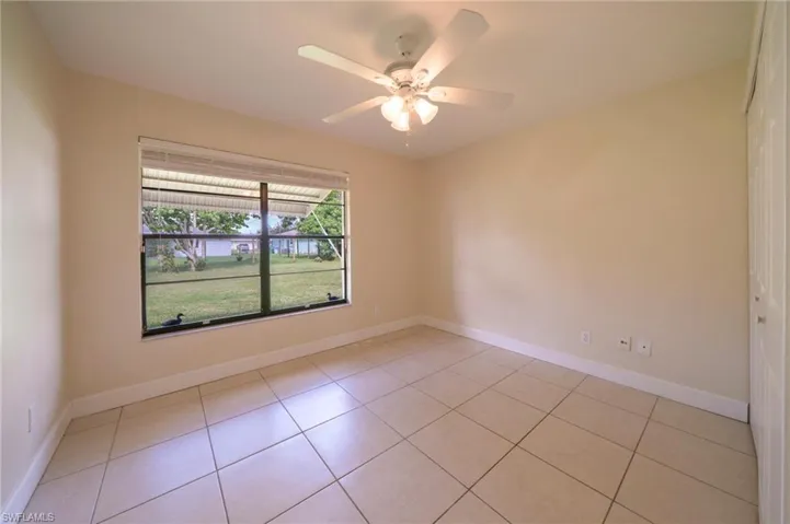Empty room featuring light tile patterned floors and a ceiling fan