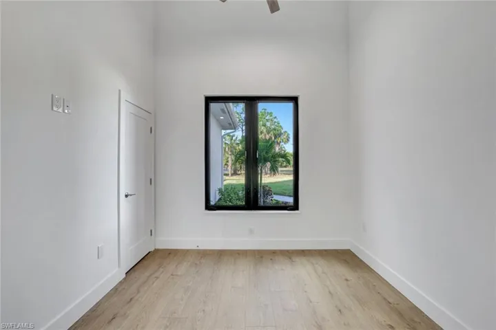 Empty room with ceiling fan and light wood-type flooring