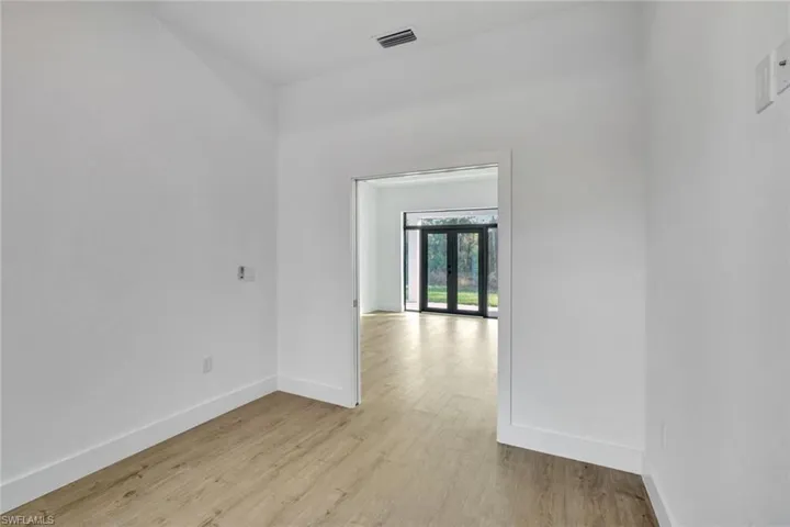Unfurnished room featuring french doors and light hardwood / wood-style floors