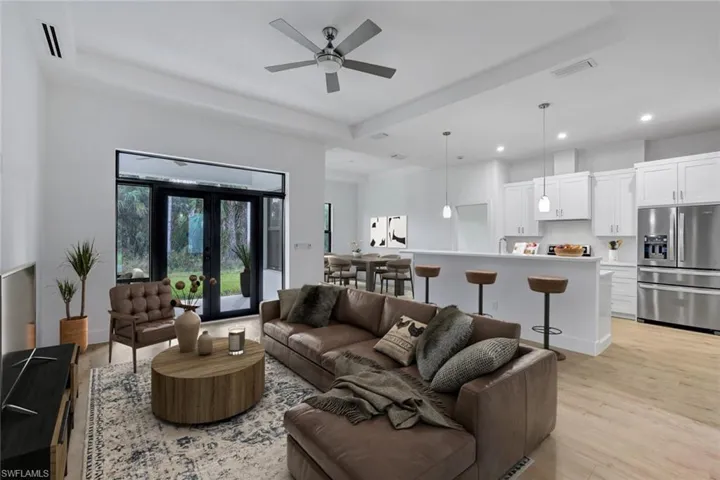 Virtually Staged-Living room with ceiling fan, french doors, and light hardwood / wood-style floors