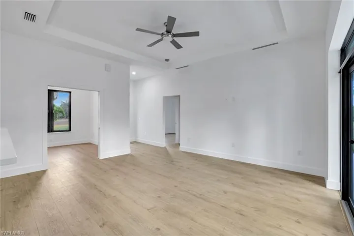 Unfurnished living room featuring ceiling fan and light wood-type flooring