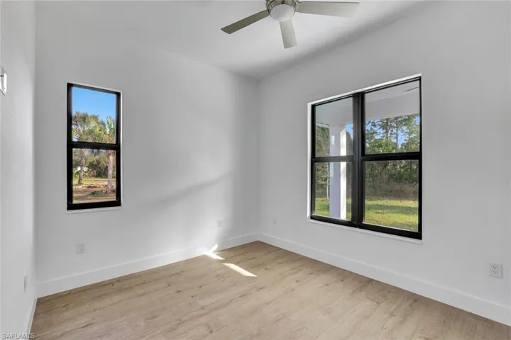 Unfurnished room featuring ceiling fan, a healthy amount of sunlight, and light wood-type flooring