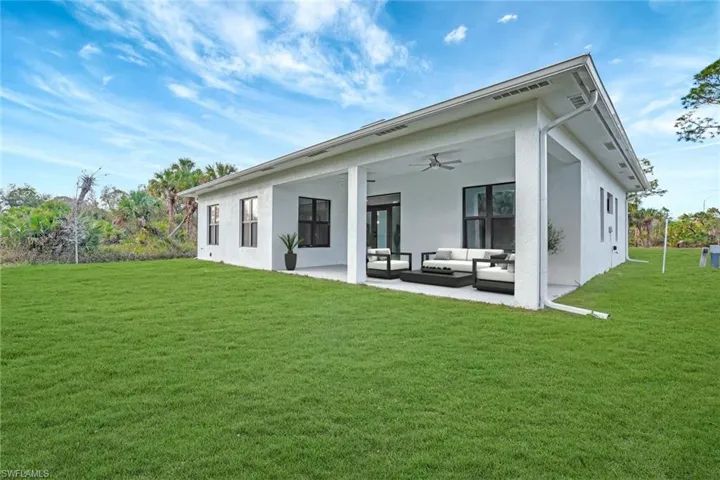 Virtually Staged-Rear view of house featuring outdoor lounge area, ceiling fan, a yard, and a patio