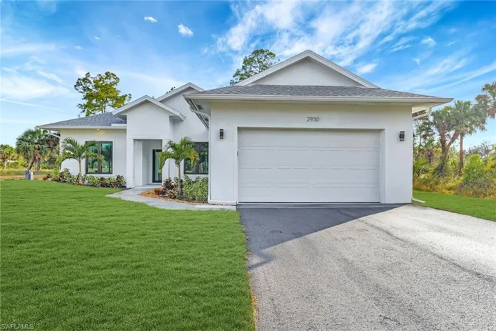 View of front of house featuring a front yard and a garage