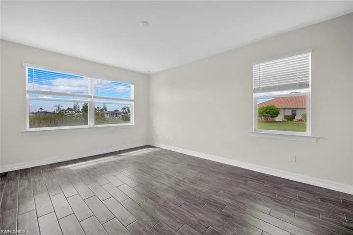 Spare room with baseboards and wood finish floors