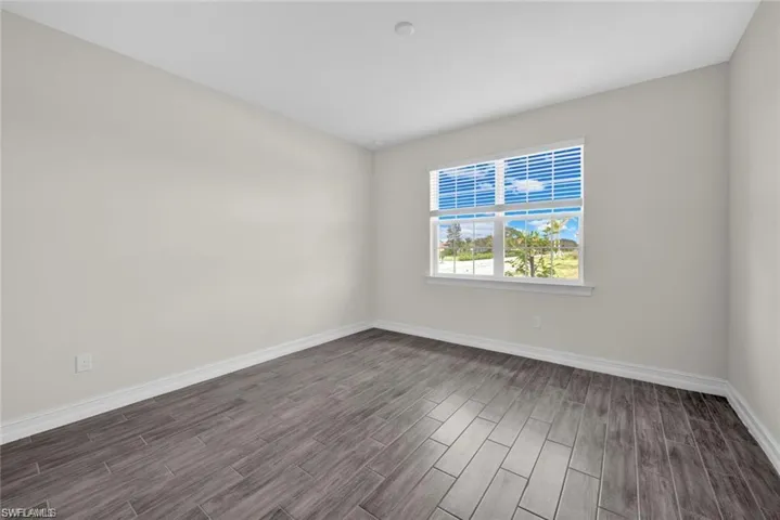 Spare room with baseboards and wood tiled floors