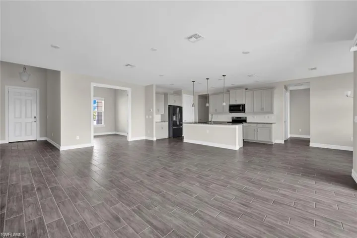 Unfurnished living room with dark wood-style flooring