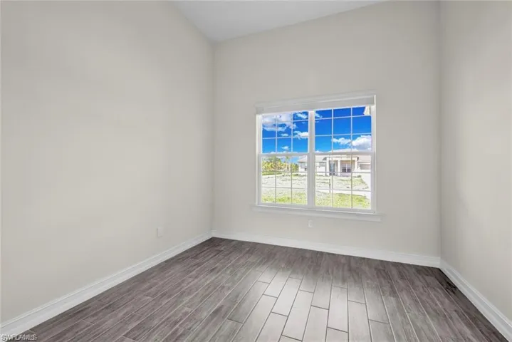 Unfurnished room with baseboards and wood finish floors
