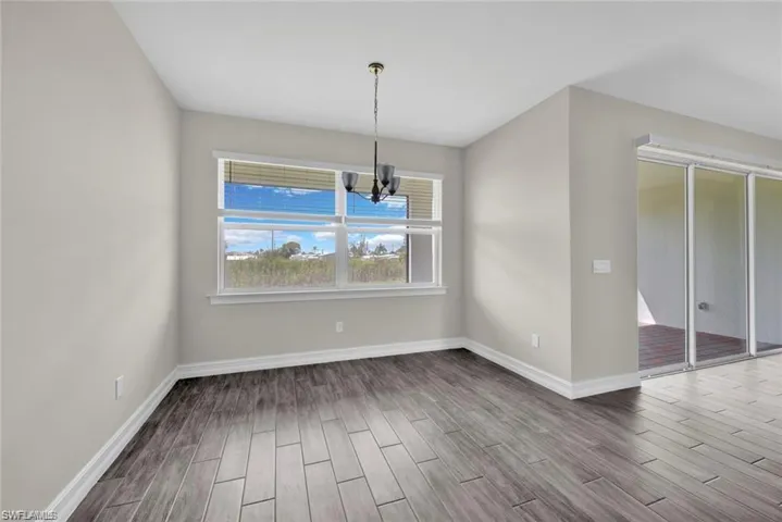 Unfurnished dining area featuring wood tiled floors and a chandelier