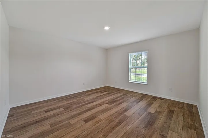Spare room featuring dark wood-type flooring