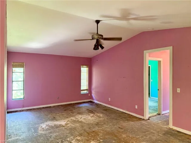 Spare room featuring lofted ceiling, a ceiling fan, and baseboards