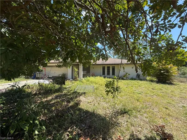 View of front of property with an attached garage, a front yard, and stucco siding
