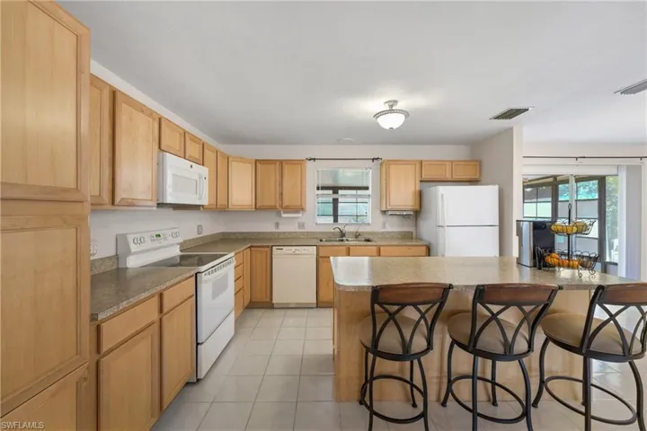 Kitchen with a center island, sink, plenty of natural light, and white appliances