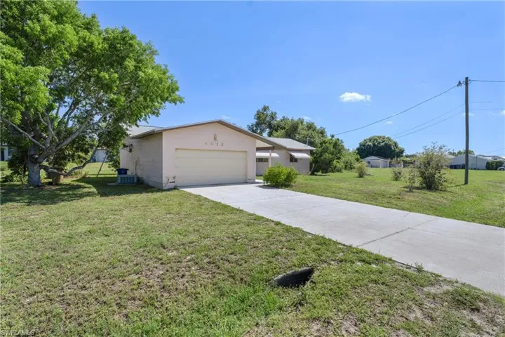 View of front of property with a front yard and a garage