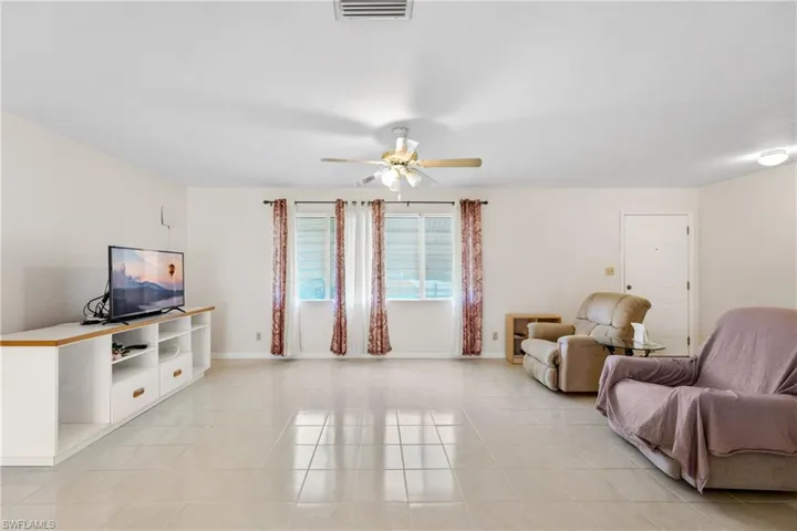 Tiled living room featuring ceiling fan