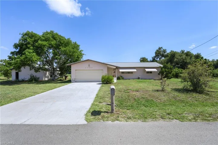 Ranch-style house with a front lawn and a garage