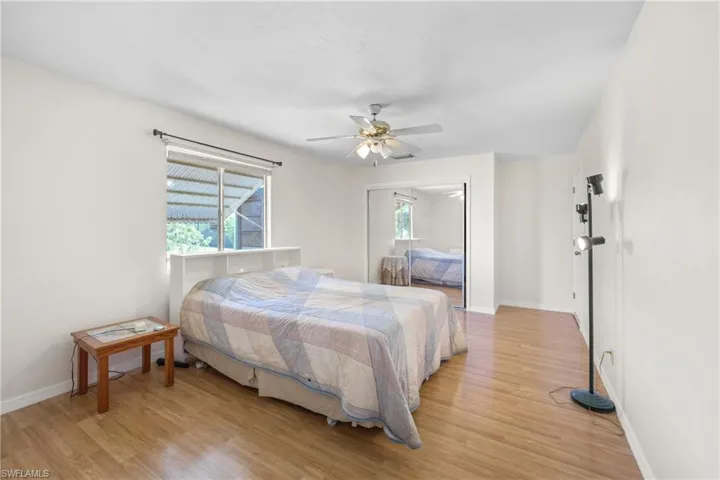 Bedroom with ceiling fan, light hardwood / wood-style flooring, and multiple windows