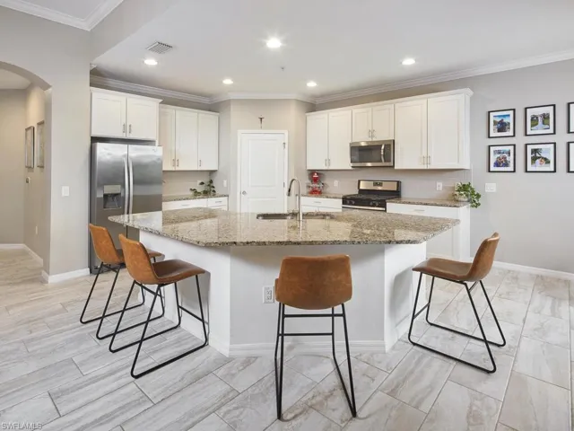 This useful island features a sink and plenty of countertop space for food prep and casual dining.