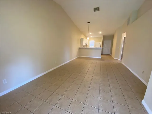 Living room from other end, showing kitchen and front door.