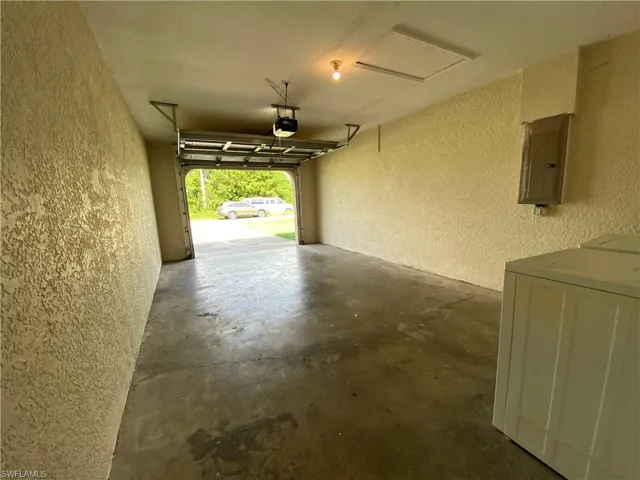 Garage featuring a electric garage door opener. Washer and Dryer hookup in garage. Water heater as well.