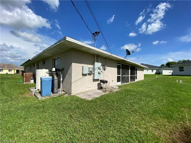 Rear view of duplex featuring a lawn.