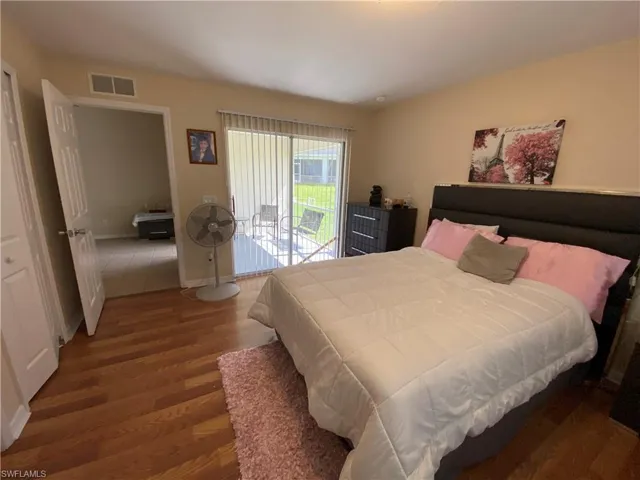 Master bedroom show casing the sliding glass door that leads to screened in lanai.