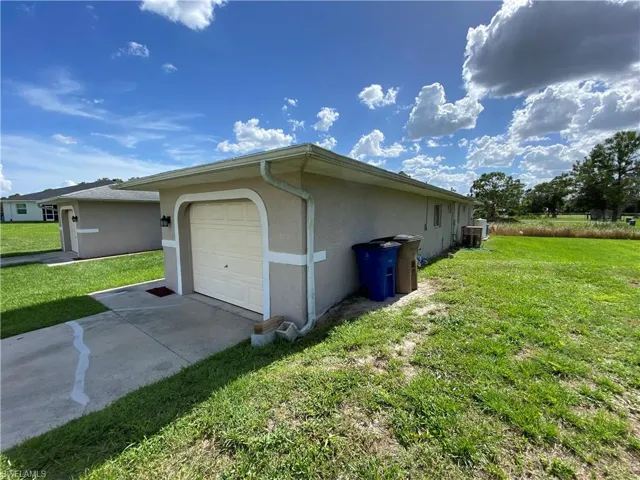 View of property exterior with a garage and a yard.